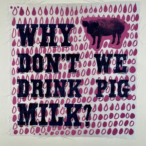 May include: A white fabric background with a pink and white pattern of raindrops. The text "WHY DON'T WE DRINK PIG MILK?" is printed in black. A pink silhouette of a pig is above the text.