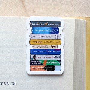 May include: A stack of colorful book-shaped magnets with the titles of popular novels. The titles include "The Book of Longings", "The Nightingale", "Glittering Hour", "The Help", "The Book Thief", "City of Girls", "The Alice Network", "The Seven Husbands of Evelyn Hugo", and "Where the Crawdads Sing".