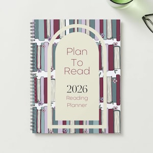May include: A spiral-bound reading planner for 2026 with a cover featuring a pattern of books in shades of purple, blue, and white. The planner has the text "Plan To Read" and "Reading Planner" on the cover.
