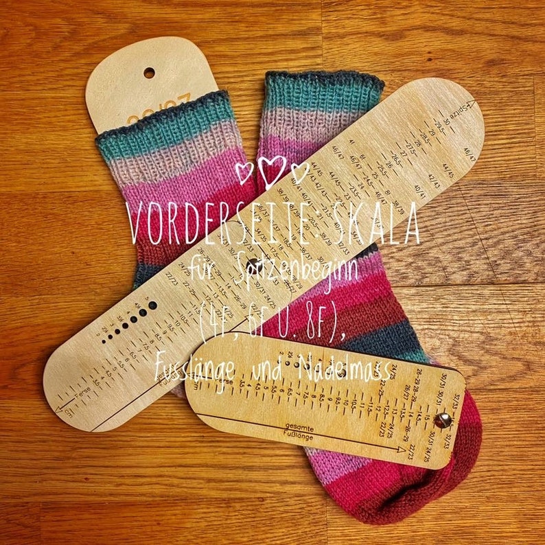 May include: Two wooden measuring tools for knitting socks. The tools are marked with measurements in inches and centimeters. The tools are labeled "VORDERSEITE SKALA f&uuml;r Spitzenbeginn (4 ff. U. 8F)." and "Fussl&auml;nge und Nadelmass".