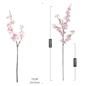 May include: Two artificial cherry blossom branches with pink flowers. The branch on the left is 29.5 inches tall and the branch on the right is 43 inches tall.