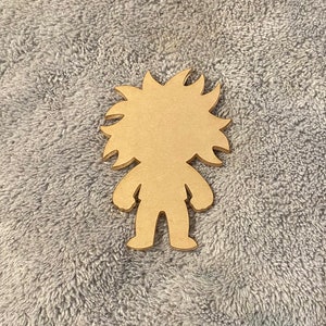 Op de afbeelding: Houten uitsnijding van een cartoonfiguur met stekelig haar. Het personage heeft een eenvoudig ontwerp zonder gezichtskenmerken.