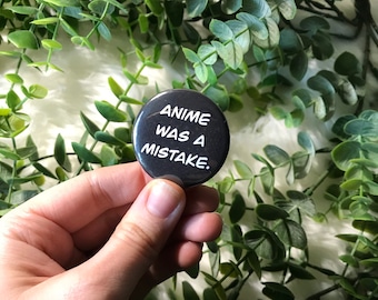 May include: A black button with white text that reads "Anime was a mistake."
