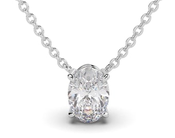 May include: A silver-toned necklace featuring a single oval-cut clear gemstone pendant held in a four-prong setting. The pendant is suspended from a delicate, thin silver-toned cable chain with small, uniform circular links that connect to the stone.