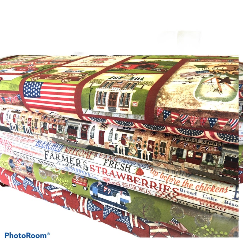 May include: Four pieces of fabric with a patriotic theme. The top fabric features a red, white, and blue American flag, a red brick building, and a sign that says "General Store". The second fabric features a red, white, and blue American flag, a sign that says "Bleached", and a sign that says "Welcome Brand". The third fabric features a sign that says "Farmers Fresh Strawberries", a sign that says "Roller Mills", and a sign that says "Bread Cake Biscuit". The fourth fabric features a sign that says "10 LBS. NET", a sign that says "General Store", and a sign that says "Complete the Chickens".