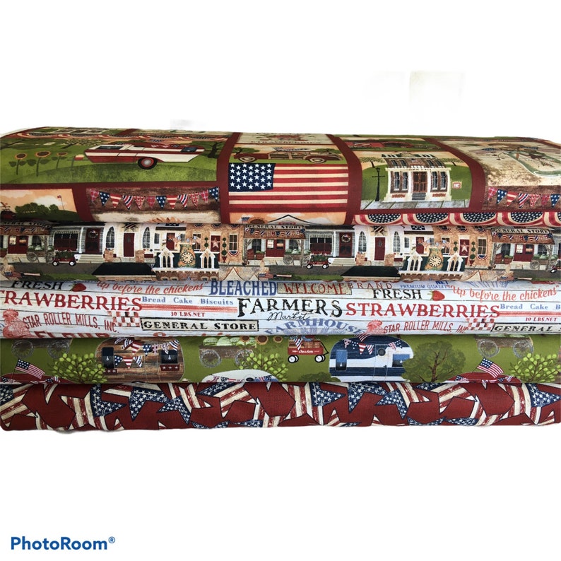 May include: A stack of four fabric panels featuring a patriotic theme with red, white, and blue stars and stripes. The panels also feature images of a general store, a farmhouse, and a red, white, and blue pickup truck. The text on the panels reads "Fresh Strawberries", "Farmers Market", "Bleached", "Welcome", and "General Store".