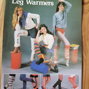 Könnte beinhalten: Ein Prospekt für gestrickte Beinstulpen mit verschiedenen Designs und Farben. Der Prospekt trägt den Titel "Leisure Arts Knitted Leg Warmers" und die Nummer "239" sowie den Preis von "1,00 $".