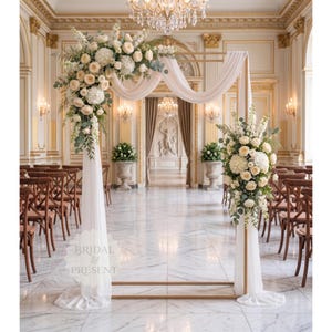 May include: An elegant wedding ceremony setup featuring a gold arch adorned with white flowers and draping fabric. The scene is set in a grand hall with marble floors, chandeliers, and rows of wooden chairs. The text "BRIDAL & PRESENT" is visible.