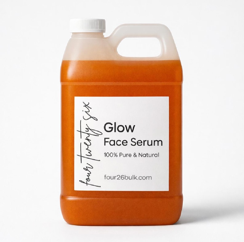 Puede incluir: Una garrafa de pl&aacute;stico transl&uacute;cido llena de suero facial naranja. La etiqueta blanca presenta el texto four twenty six, Glow Face Serum, 100% Pure & Natural y four26bulk.com. El recipiente tiene un tap&oacute;n de rosca blanco y un asa.