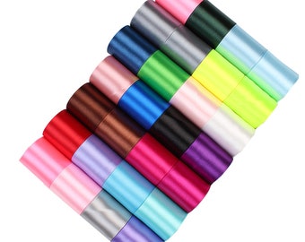 May include: A collection of 16 spools of satin ribbon in various colors, including pink, blue, green, yellow, red, purple, and brown. The ribbons are arranged in a fan shape, with the ends of the ribbons overlapping.