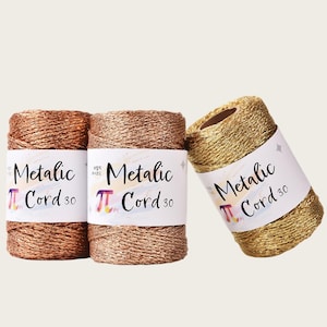 May include: Three spools of metallic cord in copper, rose gold, and gold colors. Each spool features a white paper label with the text "Metalic Cord 3.0" and a pi symbol logo. The cord has a twisted, shimmering texture suitable for crafting projects.