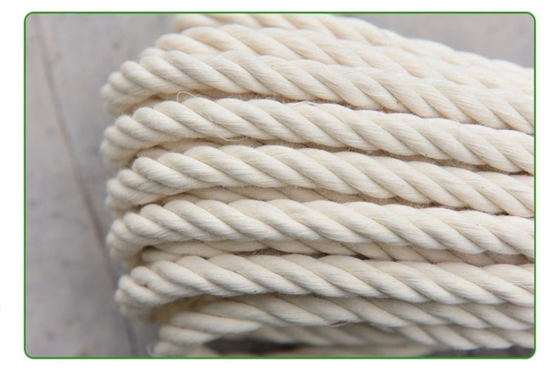 May include: Close-up of a thick, white cotton rope. The rope is twisted and has a natural, rustic look.