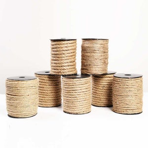 May include: Six spools of natural brown twine, each wound around a black plastic spool. The spools are arranged in a pyramid shape.
