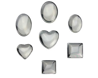 May include: Assortment of clear glass cabochons in various shapes, including round, oval, heart, and square.