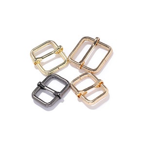 Peut inclure: Quatre boucles métalliques en différentes finitions : or, argent et noir. Les boucles sont de forme carrée avec une ouverture rectangulaire au centre.