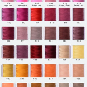 Pode incluir: Uma carta de cores de 47 carret&eacute;is de fio, dispostos em filas de sete. Os carret&eacute;is s&atilde;o numerados de 800 a 847. As cores variam do branco ao p&ecirc;ssego, rosa, vermelho, castanho, laranja e amarelo.