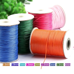 May include: Spools of waxed cotton cord in various colors, including blue, green, pink, orange, and white. The spools are labeled with the cord thickness in millimeters: 0.5mm, 0.8mm, 1mm, 1.5mm, 2mm, 2.5mm, 3mm, 3.5mm, and 4mm.