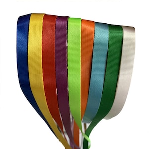 Op de afbeelding: Een set van tien kleurrijke satijnen lint lanyards. De linten zijn in de volgende kleuren: blauw, geel, rood, paars, groen, oranje, lichtblauw, donkergroen, wit en roze.