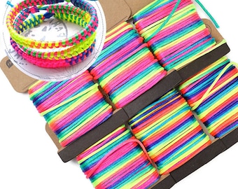 May include: A pack of six rainbow coloured embroidery floss spools. Each spool is wound with a multi-coloured thread that includes pink, green, blue, yellow, and orange.