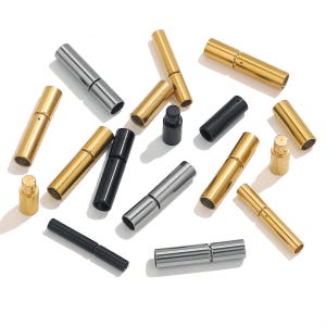 May include: A collection of cylindrical jewelry clasps in gold, silver, and black metal finishes. These tubular connectors feature a two-piece design that slides together, with some pieces shown separated to reveal the internal male and female ends.