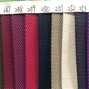 May include: A close-up of 10 fabric swatches in various colors, including dark purple, red, navy blue, beige, white, dark blue, purple, and blue. The swatches are labeled with numbers from 245 to 255.