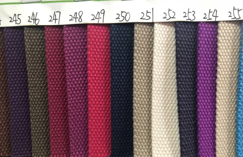 May include: A close-up of 10 fabric swatches in various colors, including dark purple, red, navy blue, beige, white, dark blue, purple, and blue. The swatches are labeled with numbers from 245 to 255.