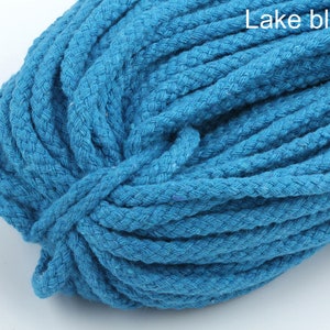 Może przedstawiać: Zbliżenie na szpulę grubego, niebieskiego sznurka bawełnianego. Sznurek jest pleciony i ma fakturowaną powierzchnię. Tekst "Lake blue" jest widoczny w prawym g&oacute;rnym rogu obrazu.