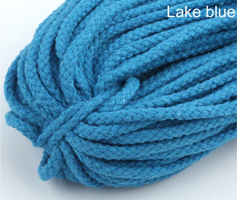 Może przedstawiać: Zbliżenie na szpulę grubego, niebieskiego sznurka bawełnianego. Sznurek jest pleciony i ma fakturowaną powierzchnię. Tekst "Lake blue" jest widoczny w prawym g&oacute;rnym rogu obrazu.
