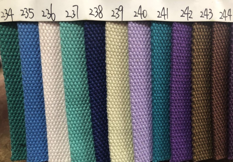May include: A close-up of 11 fabric swatches in various colors, including green, blue, white, beige, purple, teal, and brown. The swatches are numbered 234 through 244.