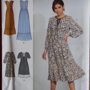 May include: Simplicity sewing pattern K8872 for dresses, sizes U.S. 12-20. The pattern features various dress designs, including a floral print dress with long sleeves and a tie neckline. Produced in association with sew.
