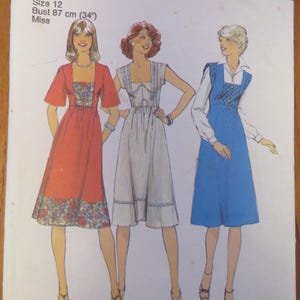 Pode incluir: Um envelope de molde de costura Style 1611 para um vestido tamanho 12 com busto de 87 cm. A ilustração mostra três variações de vestido: um vermelho com detalhes florais, um branco com acabamento azul e um azul sobre camisa branca.