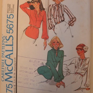 May include: A vintage McCall's sewing pattern, number 5675, showcasing blouse designs. The pattern includes illustrations of blouses with long sleeves and various necklines. The cover displays size, price, and pattern information.