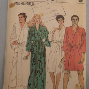 May include: A Very Easy Vogue sewing pattern envelope, number 8155, size small. The front features illustrations of four individuals wearing various styles of robes, including a long white robe, a long green patterned robe, and two shorter robes.