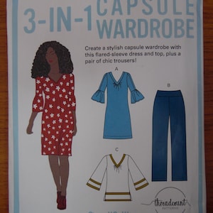 May include: A sewing pattern for a 3-in-1 capsule wardrobe. The pattern includes a flared-sleeve dress, a top, and trousers. The dress is red with white star patterns. The top is white with gold trim. Sizes XS-XL.