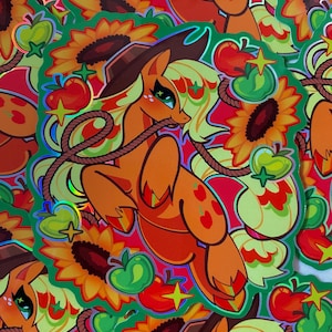 May include: A sticker featuring a cartoon pony with a cowboy hat, wearing a red and orange outfit with apples on it. The pony is surrounded by sunflowers, apples, and green leaves. The sticker has a holographic finish.