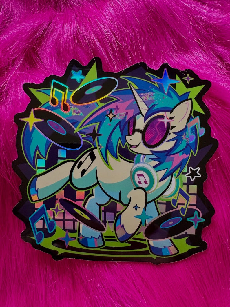 May include: A die-cut sticker featuring a light blue unicorn with a multicolored mane, wearing pink-tinted sunglasses and headphones. The unicorn is surrounded by floating black vinyl records, musical notes, and stars against a dark background.