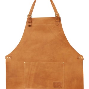 May include: A brown leather apron with adjustable straps and a large pocket. The apron has a small leather patch with a logo on the front.