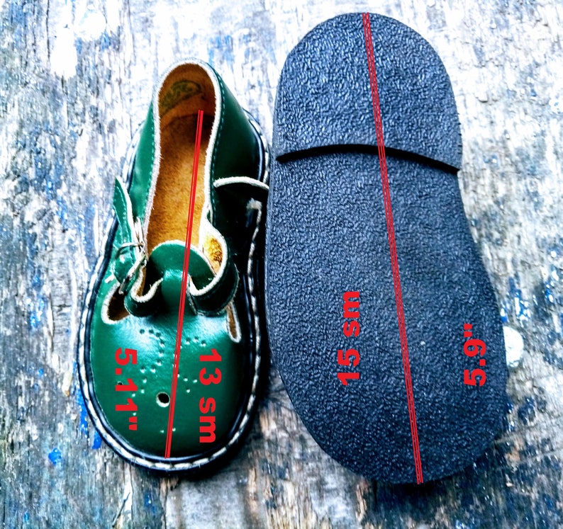 Pode incluir: Sapatos de couro verde para crian&ccedil;as com fecho de fivela. Os sapatos s&atilde;o tamanho 13 UK e 5,5 polegadas. A sola do sapato &eacute; preta.