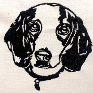 May include: Black and white embroidered image of a dog's head with a collar.