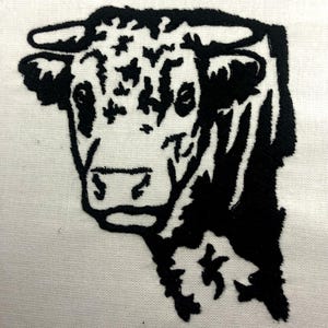 May include: Black and white embroidered image of a bull's head.