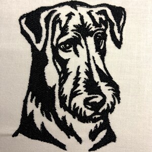 以下が含まれることがあります： 犬の頭部の白黒刺繍。犬は短く硬い毛並みで、真剣な表情をしている。