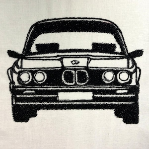 May include: Black embroidered car design on a white fabric. The car is a classic model, with detailed stitching outlining the body, headlights, and grille. The design is centered, showcasing the front of the vehicle.