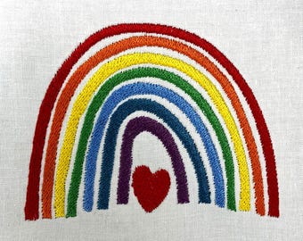May include: Embroidered rainbow design with red, orange, yellow, green, blue, and purple arches. A red heart is centered below the rainbow. The design is on a white fabric background. This item is suitable for various craft projects.