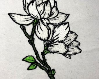May include: Embroidered white magnolia flowers with green leaves on a white fabric background.