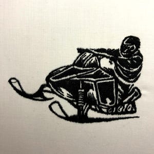 May include: Black and white embroidered image of a person riding a snowmobile. The snowmobile has a long, curved track and a seat for the rider. The rider is wearing a helmet and a jacket.