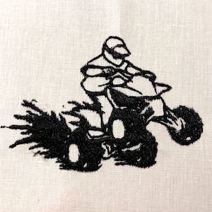 May include: Black and white embroidered image of a person riding an ATV, with a trail of dirt behind the vehicle.