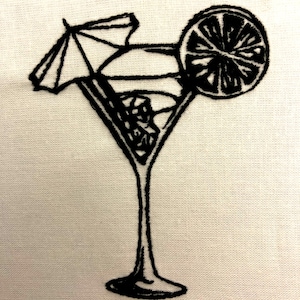 May include: Black and white embroidered image of a martini glass with a lime wedge and a small umbrella.