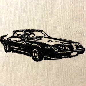 May include: Black and white embroidered image of a classic car with a convertible top.