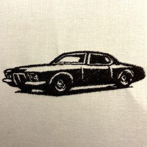May include: Black and white embroidered image of a classic car on a white fabric background.