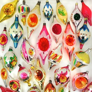 May include: A collection of vintage Christmas ornaments in various shapes and colors. The ornaments feature a mix of silver, gold, red, pink, and blue hues. Some have intricate designs and patterns, while others have a simple, elegant look. A festive assortment for holiday decor.